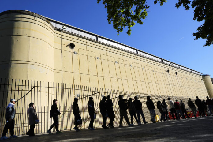 Imagen de archivo de inmigrantes haciendo fila en Barcelona para presentar su documentación ante el proceso de regularización puesto en marcha por el Gobierno español. EFE/Alejandro García
