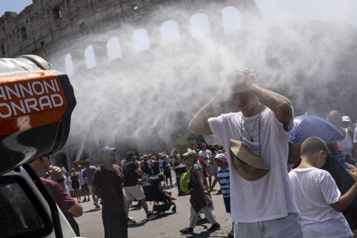 Los visitantes se refrescan entre nebulizadores de agua instalados cerca del Coliseo en Roma, 26 de junio de 2026. EFE/MASSIMO PERCOSSI
