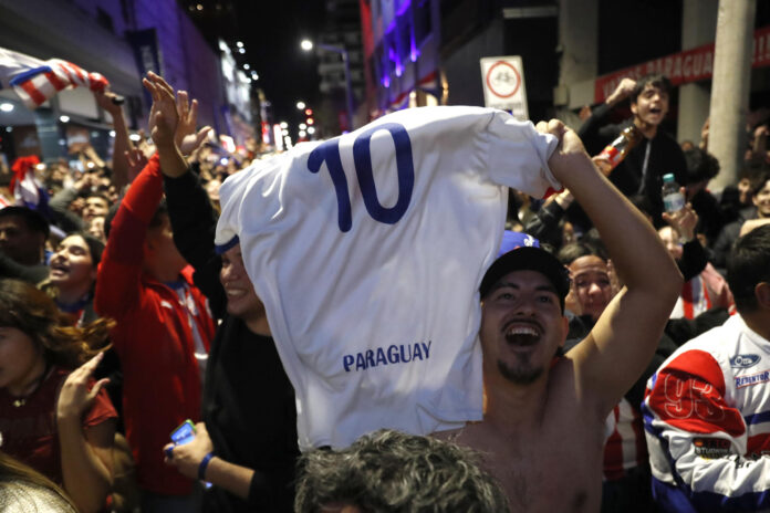 Aficionados celebran la victoria de Paraguay ante Alemania en el Mundial de la FIFA 2026 este lunes, en Asunción (Paraguay). EFE/ Juan Pablo Pino

