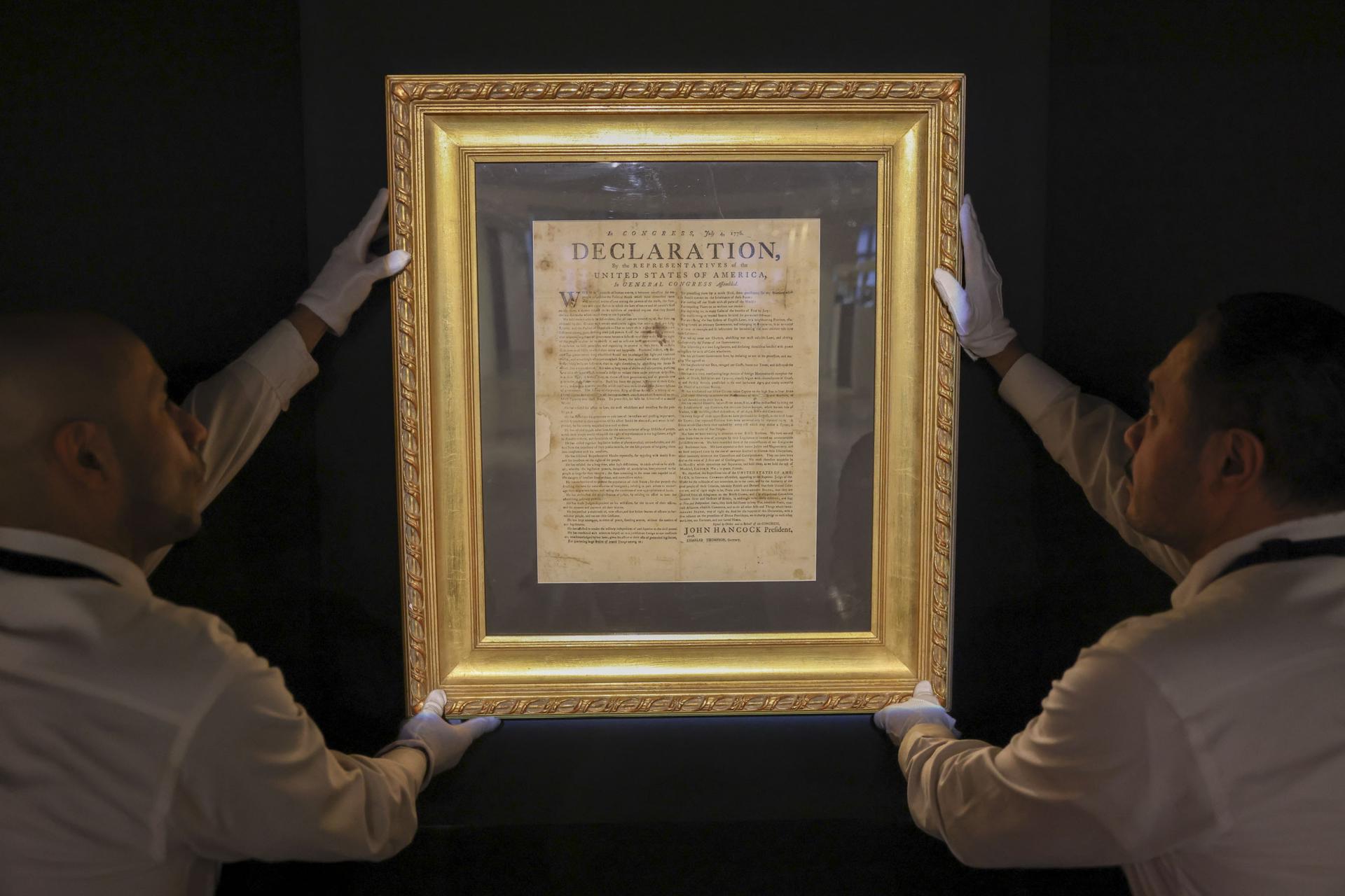 Fotografía de archivo del 17 de enero de 2026 que muestra a personas sosteniendo la Declaración de Independencia: el folleto de Exeter de julio de 1776 en la casa de subastas Sotheby’s de Nueva York (EE.UU.). EFE/ Sarah Yenesel
