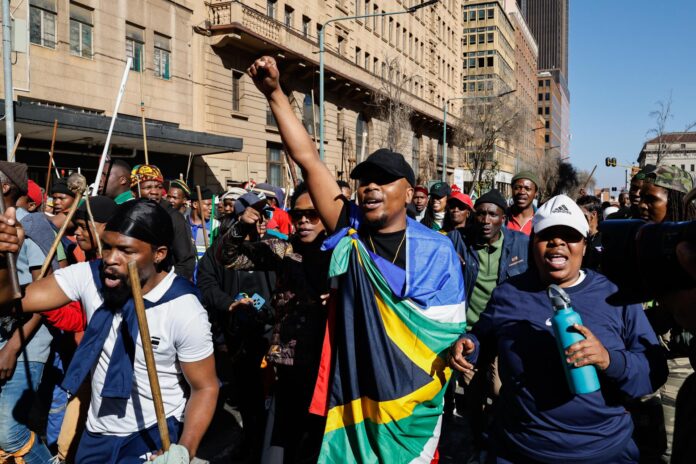 Miembros de la comunidad zulú participan en una manifestación contra los inmigrantes indocumentados durante una jornada de movilizaciones del movimiento nacional antiinmigración en Johannesburgo (Sudáfrica) este 30 de junio de 2026. Se han convocado marchas en todo el país, en las que numerosas organizaciones agrupadas bajo el paraguas del movimiento 'March and March' saldrán a las calles de las principales ciudades para protestar por el elevado número de inmigrantes, tanto con situación regular como irregular, que viven en Sudáfrica. Aunque los manifestantes lanzaron un ultimátum exigiendo que los extranjeros abandonaran Sudáfrica antes del 30 de junio, el Gobierno sudafricano rechazó expresamente la convocatoria y declaró el 30 de junio como un día laborable normal. EFE/EPA/KIM LUDBROOK
