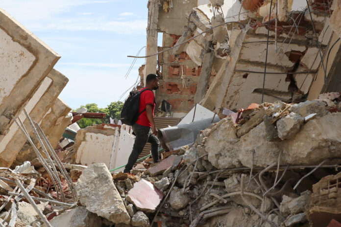 Un hombre camina sobre escombros de edificaciones destruidas este martes, en La Guaira (Venezuela). EFE/ Raúl Martínez
