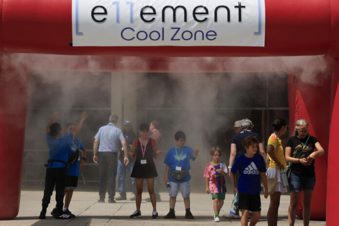 Personas se refrescan en una carpa de nebulización debido a las altas temperaturas este martes, en la plaza Nathan Phillips en Toronto (Canadá). EFE/ Bienvenido Velasco
