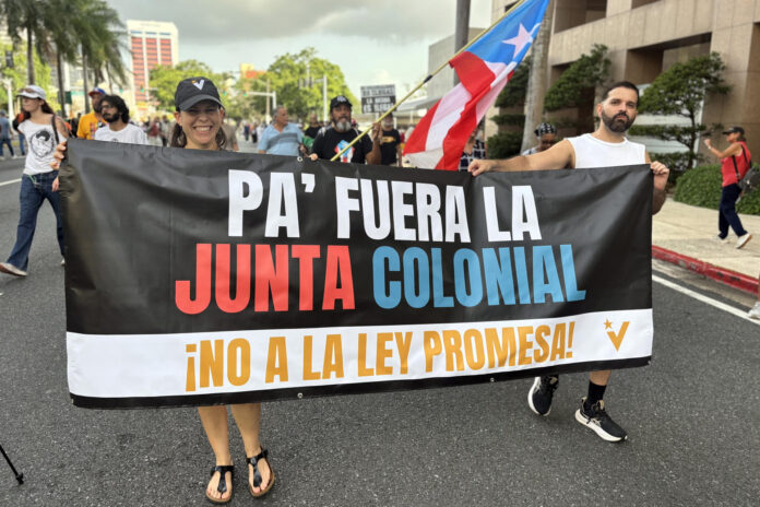 Personas sostienen un cartel durante una manifestación para exigir la salida de la Junta de Supervisión Fiscal (JSF), un controvertido ente impuesto hace una década por Estados Unidos para reestructurar la deuda de Puerto Rico y controlar sus finanzas públicas, este martes en San Juan (Puerto Rico). EFE/ Esther Alaejos
