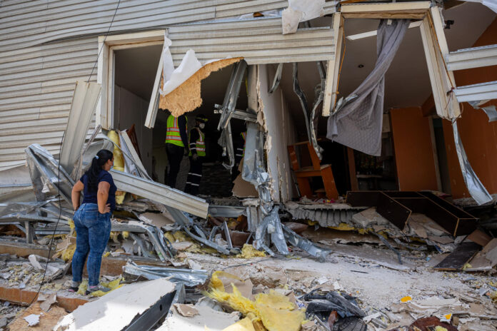 Rescatistas y ciudadanos fueron captados este 30 de junio al continuar con las labores de búsqueda y remoción de escombros en un edificio afectado por los terremotos del pasado 24 de junio, en La Guaira (Venezuela). EFE/Miguel Gutiérrez
