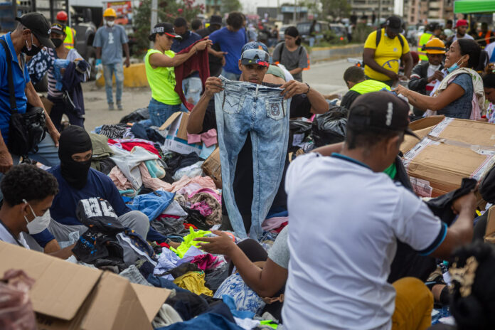 Personas buscan ropa en un campamento instalado frente a los edificios que se derrumbaron durante los terremotos en La Guaira, Venezuela, 30 de junio de 2026. EFE/ Miguel Gutierrez
