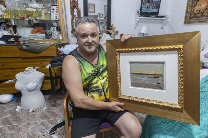 Andrés Hurtado, un vecino de Murcia, muestra este miércoles en su casa el cuadro del pintor valenciano Joaquín Sorolla que encontró en la calle, después que sus propietarios lo dejaran por olvido en la acera de una calle de Sevilla mientras cargaban su coche antes de salir de viaje. EFE/Marcial Guillén
