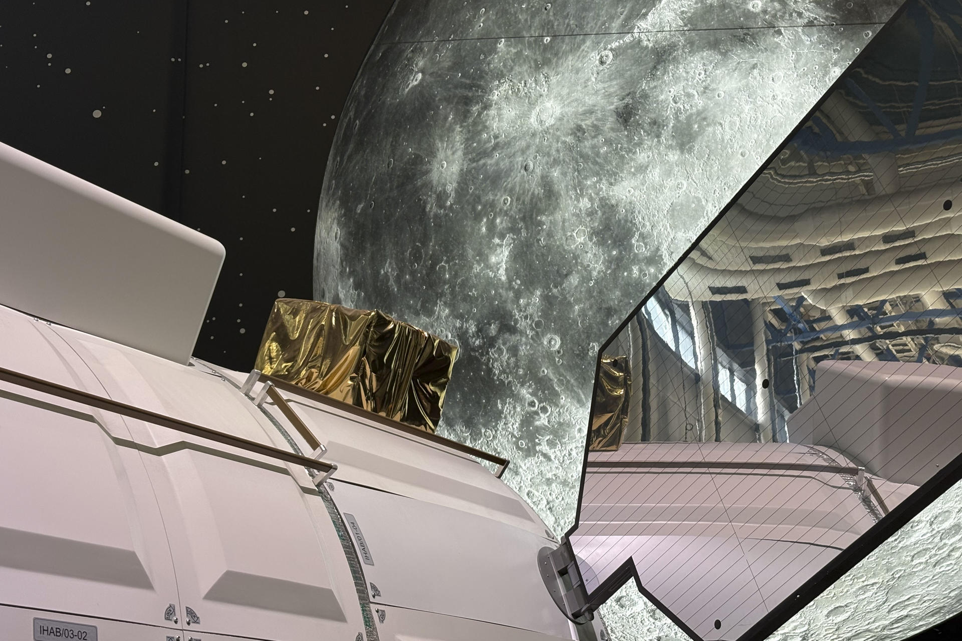 Vista de un módulo para el viaje espacial de la Agencia Espacial Europea expuesto frente a un panel que replica la Luna en la Ciudad de las Ciencias y la Industria de París este miércoles. EFE/ Pol Lloberas Cardona
