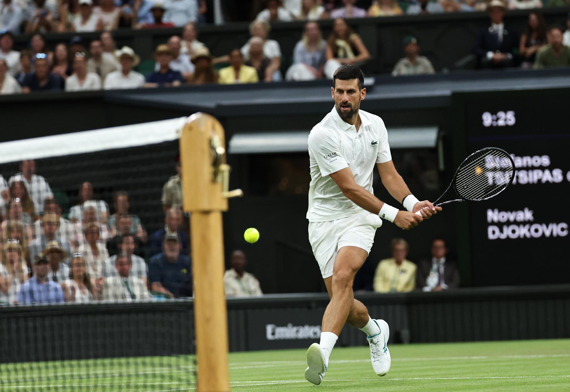 Novak Djokovic, de Serbia, en acción durante su partido de segunda ronda del torneo individual masculino de Wimbledon contra Stefanos Tsitsipas, de Grecia. EFE/EPA/NEIL HALL
