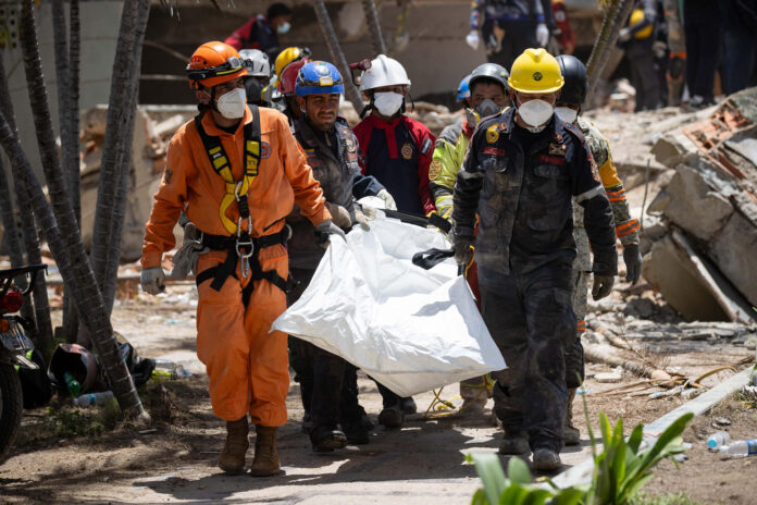Rescatistas recuperan un cuerpo de los escombros de un edificio afectado por los terremotos, este miércoles, en La Guaira (Venezuela). EFE/ Ronald Peña R
