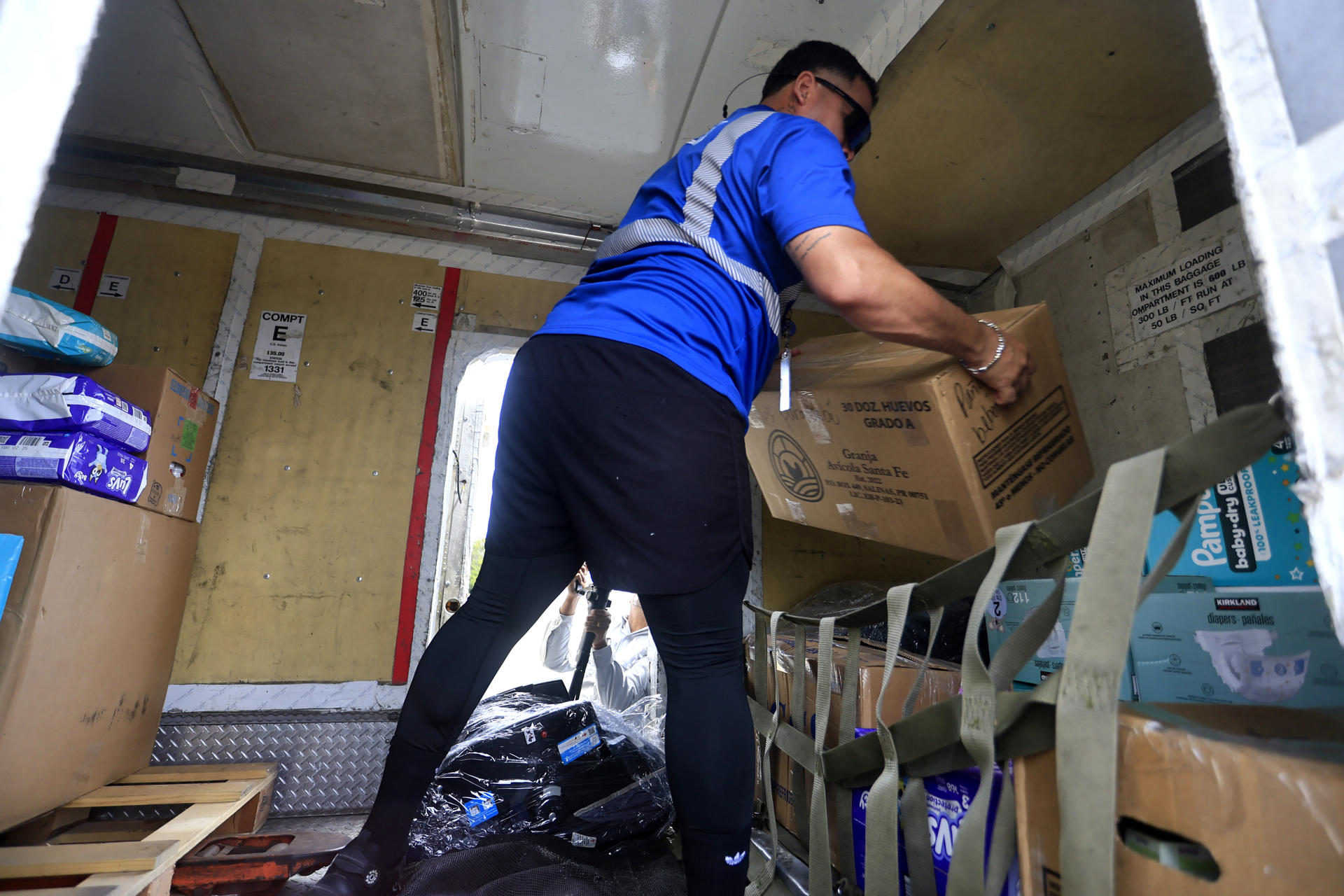 Una persona carga un avión con ayuda humanitaria previo a la salida de los primeros dos vuelos con destino a Venezuela este miércoles, en el Aeropuerto Internacional Luis Muñoz Marín, en San Juan (Puerto Rico). EFE/ Thais Llorca
