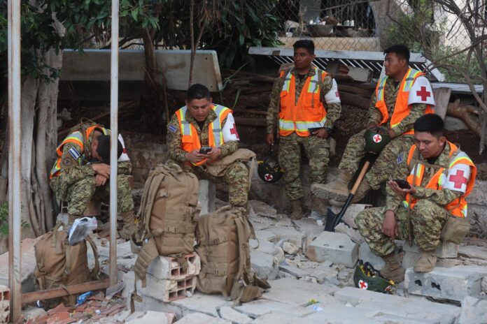 Rescatistas descansan tras la búsqueda de personas desaparecidas por el doble terremoto de magnitudes 7,2 y 7,5, este miércoles, en Catia La Mar, La Guaira (Venezuela). EFE/ Miguel Gutiérrez
