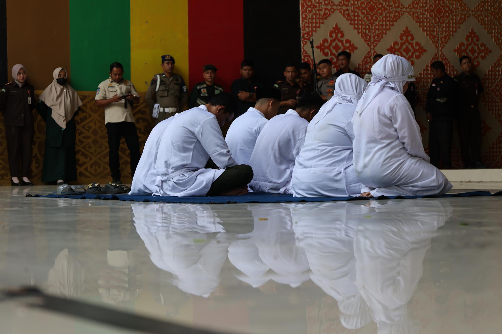 Un grupos de indonesios condenados a castigos corporales por un tribunal islámico de Indonesia.
EFE/EPA/HOTLI SIMANJUNTAK
