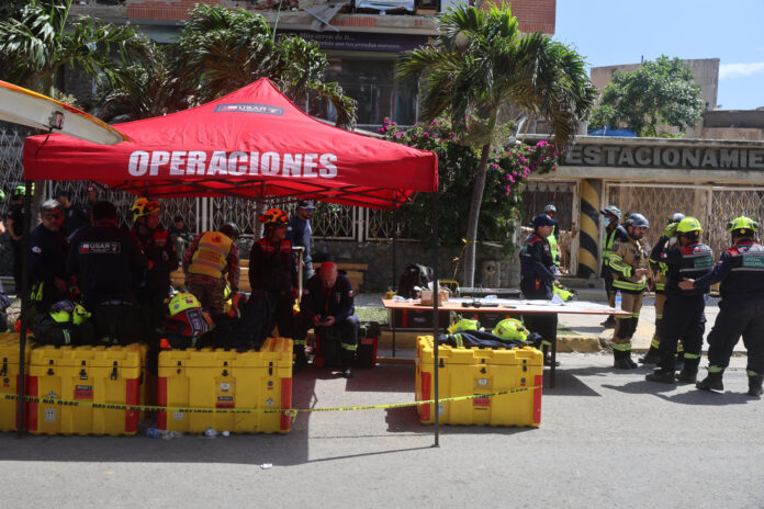 Un grupo de rescatistas de Chile trabajando el miércoles en Catia La Mar, La Guaira (Venezuela), para sacar a Hernán Gil, un venezolano que llevaba una semana bajo los escombros de un edificio tras los terremotos. EFE/ Miguel Gutiérrez
