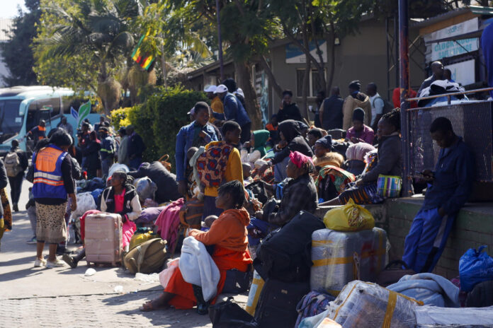 Ciudadanos de Zimbabue y Malaui en la terminal de autobuses de Road Port, en Harare, capital de Zimbabue, adonde llegaron esta semana huyendo de ataques xenófobos en Sudáfrica. Miles de zimbabuenses han cargado autobuses con maletas, mantas y otras pertenencias en las últimas semanas, en ocasiones tras acampar durante días ante la Embajada de Zimbabue en Pretoria, para volver a su país por el miedo a los ataques xenófobos ocurridos en Sudáfrica en los últimos meses.EFE/ Chengetai Zvauya

