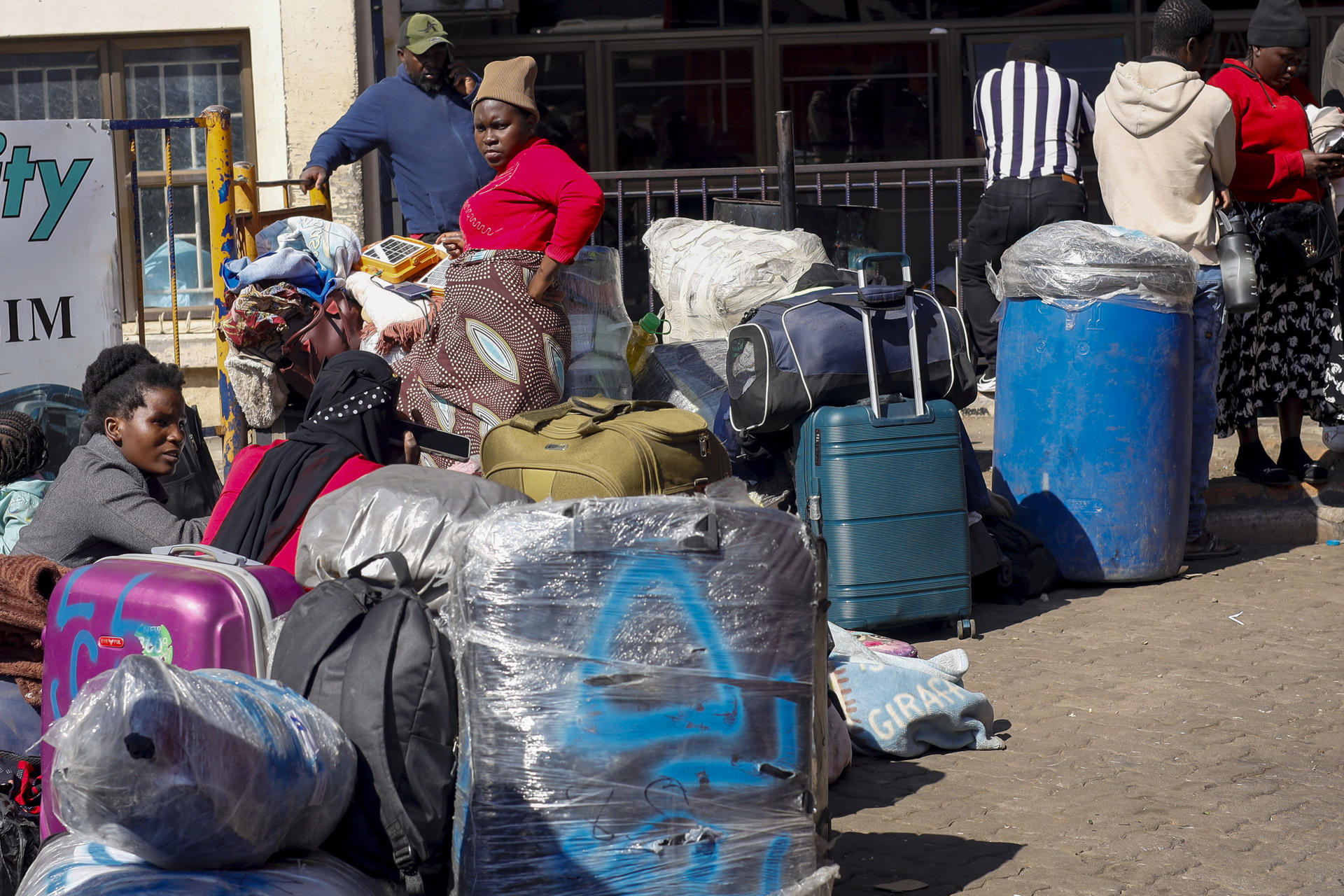 Ciudadanos de Zimbabue y Malaui en la terminal de autobuses de Road Port, en Harare, capital de Zimbabue, adonde llegaron esta semana huyendo de ataques xenófobos en Sudáfrica. Miles de zimbabuenses han cargado autobuses con maletas, mantas y otras pertenencias en las últimas semanas, en ocasiones tras acampar durante días ante la Embajada de Zimbabue en Pretoria, para volver a su país por el miedo a los ataques xenófobos ocurridos en Sudáfrica en los últimos meses.EFE/ Chengetai Zvauya