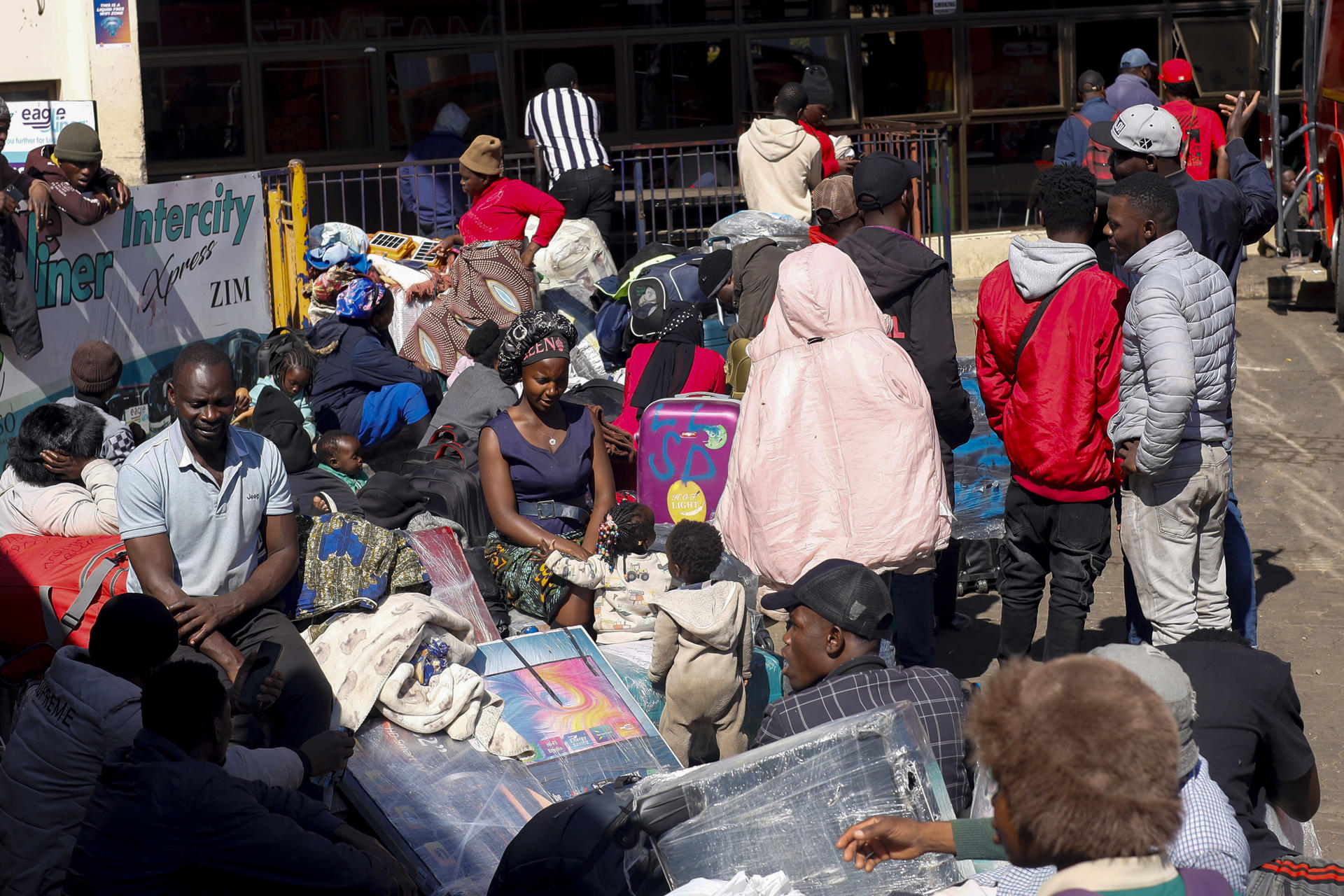 Ciudadanos de Zimbabue y Malaui en la terminal de autobuses de Road Port, en Harare, capital de Zimbabue, adonde llegaron esta semana huyendo de ataques xenófobos en Sudáfrica. Miles de zimbabuenses han cargado autobuses con maletas, mantas y otras pertenencias en las últimas semanas, en ocasiones tras acampar durante días ante la Embajada de Zimbabue en Pretoria, para volver a su país por el miedo a los ataques xenófobos ocurridos en Sudáfrica en los últimos meses.EFE/ Chengetai Zvauya