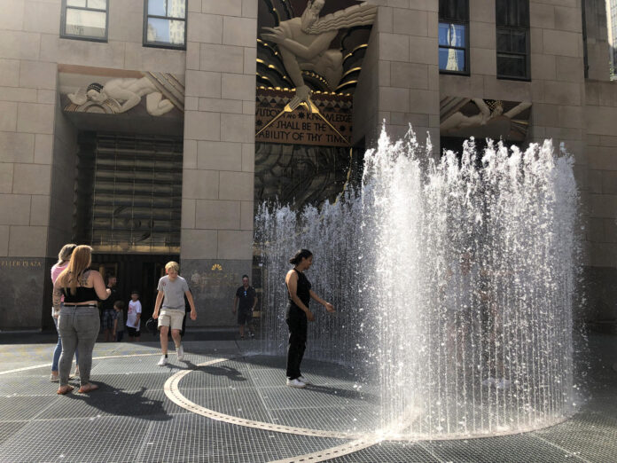 Unas personas se refrescan de la ola de calor dentro de las fuentes de agua pública en la plaza del Rockefeller Center en Nueva York (EE.UU.). Imagen de archivo. EFE/Javier Otazu

