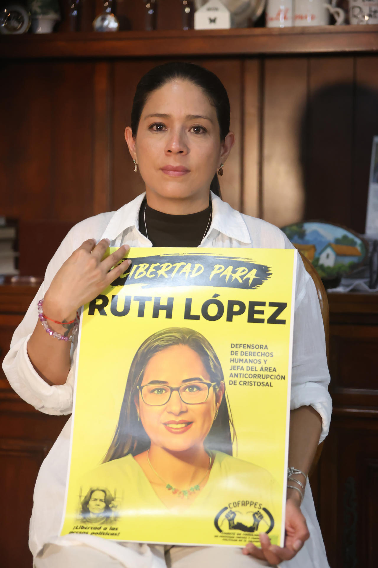 Claudia López posa con un cartel de su hermana, la defensora de derechos humanos, la abogada Ruth López, durante una entrevista con EFE en San Salvador (El Salvador). EFE/ Javier Aparicio