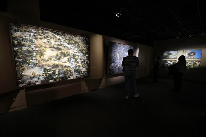 Personas observan la exposición fotográfica 'Tlachtli, espacios del juego sagrado' del mexicano Santiago Arau que propone una mirada contemporánea al ancestral juego de pelota mesoamericano, este jueves, en el Museo Nacional de Antropología de Ciudad de México (México). EFE/José Méndez
