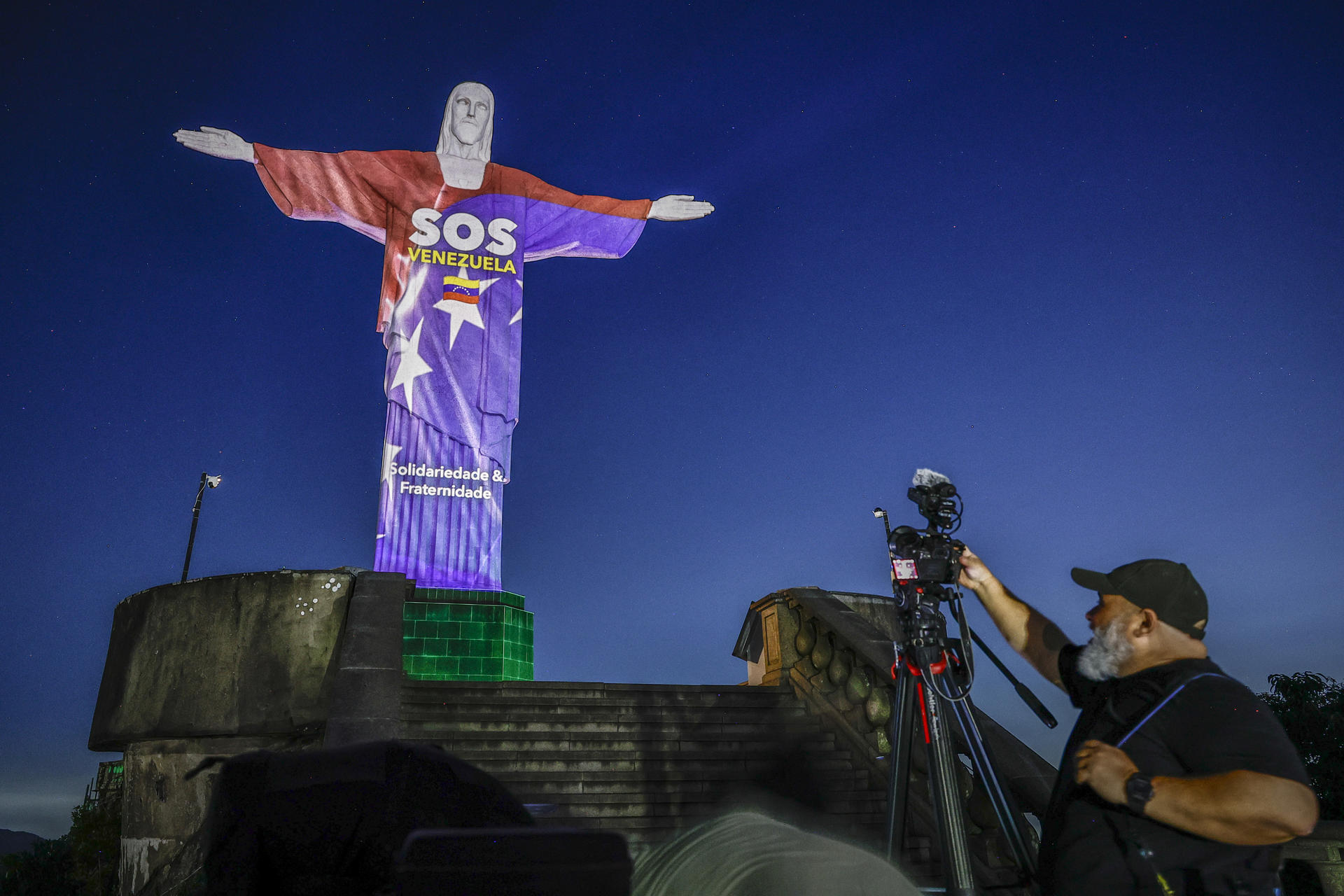 Una persona observa el monumento al Cristo Redentor este jueves, con una proyección en homenaje a las víctimas de los terremotos que azotaron a Venezuela la semana pasada, en Río de Janeiro (Brasil). EFE/André Coelho