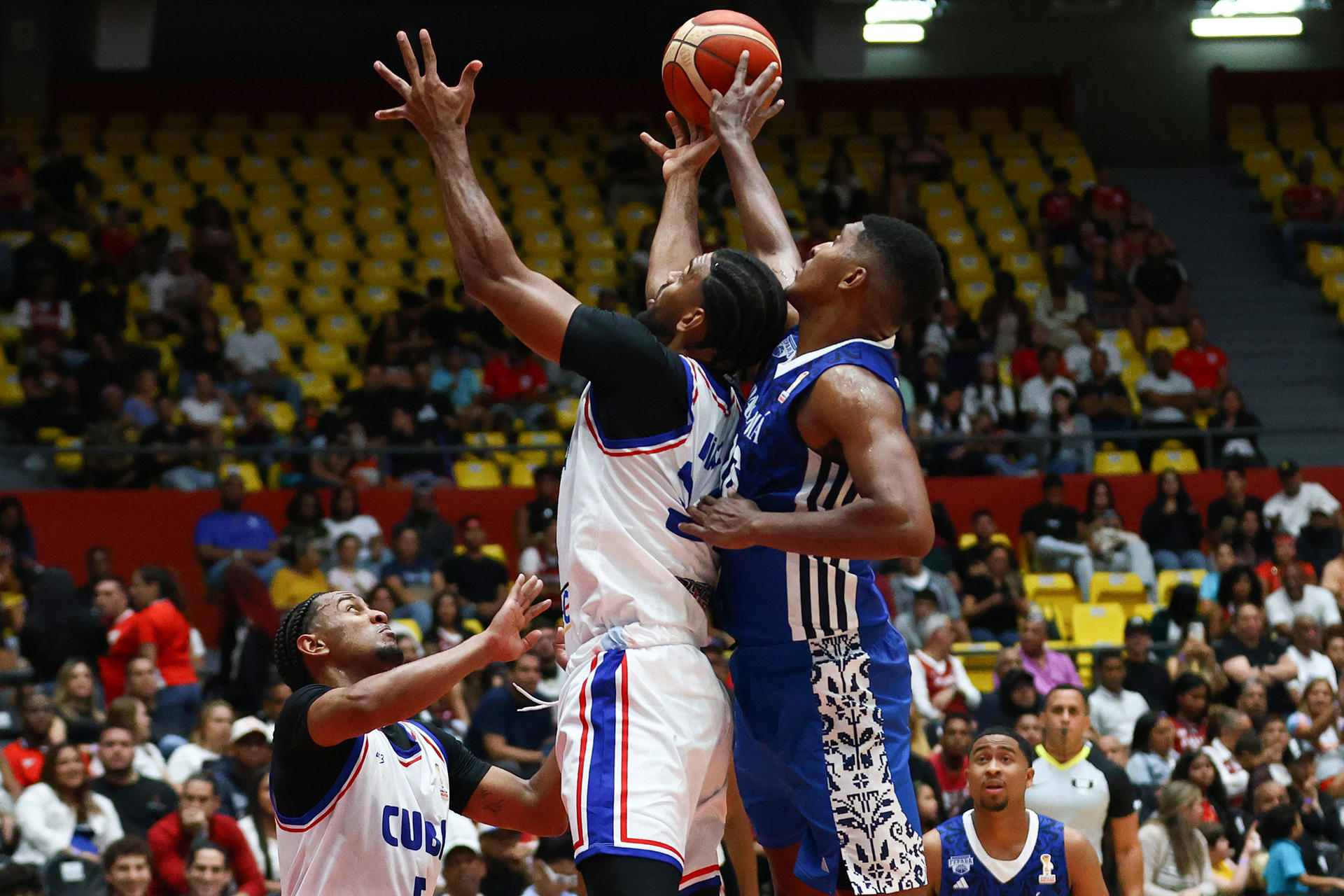 Trevor Gaskins (d), de Panamá, disputa un balón con Marlon Diaz (c), de Cuba, en un partido del grupo D por la primera ronda clasificatoria a la Copa Mundial de Baloncesto FIBA 2027 entre Panamá y Cuba en la Arena Roberto Durán en Ciudad de Panamá (Panamá). EFE/ Carlos Lemos