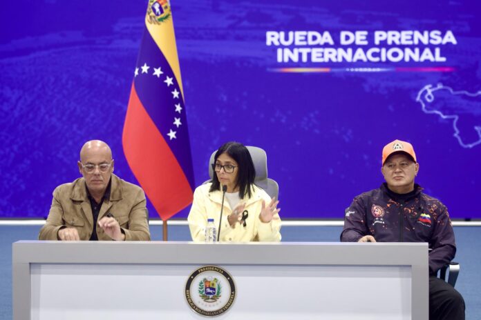 La presidenta encargada de Venezuela, Delcy Rodríguez (c), habla durante una rueda de prensa junto al presidente de la Asamblea Nacional (AN), Jorge Rodríguez (i), y el ministro del Interior, Diosdado Cabello, este jueves, donde dijo que es 