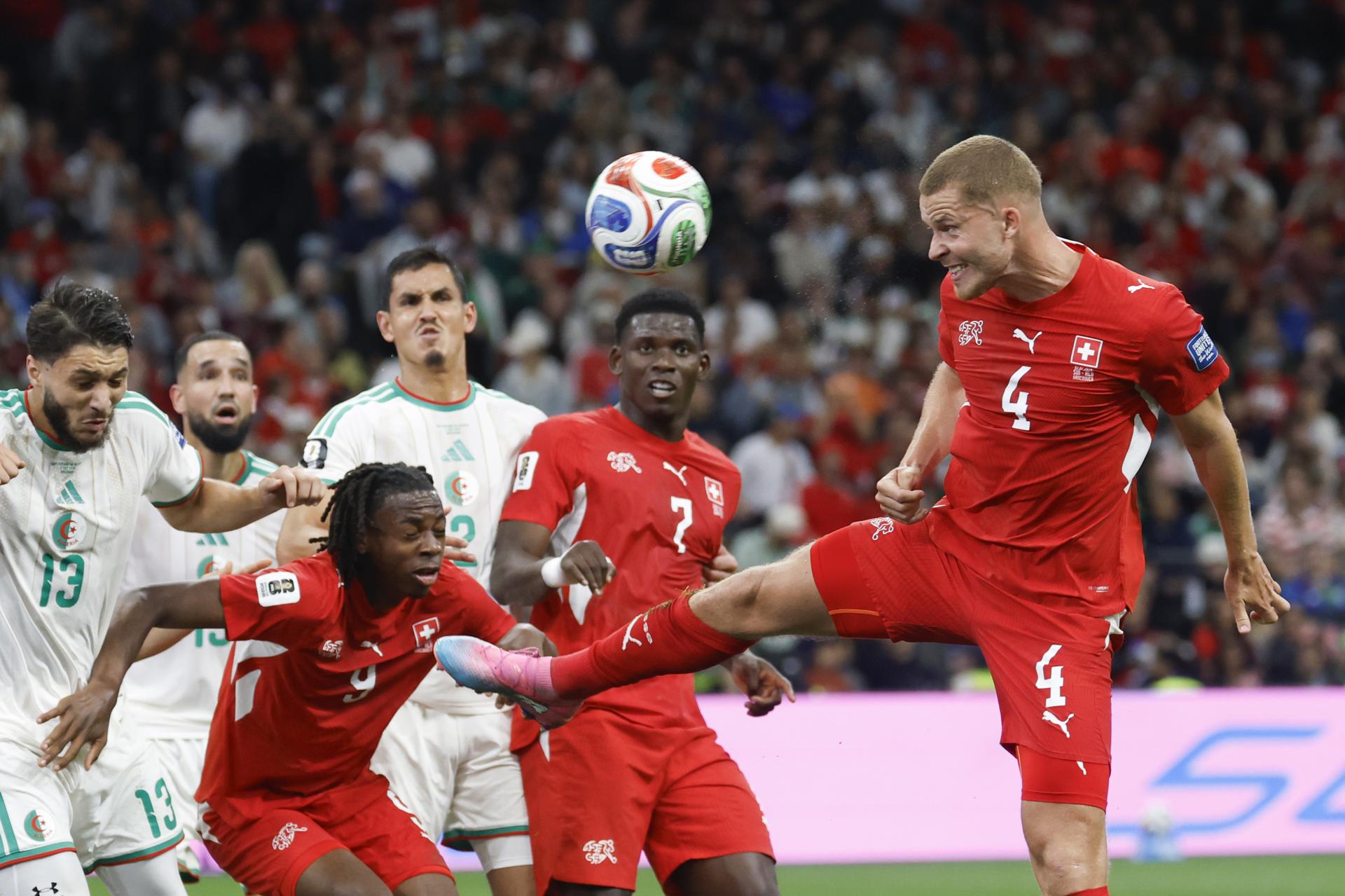 El suizo Nico Elvedi (der.) remata de cabeza tras un córner, ante el argelino Jaouen Hadjam (izq.) y sus compañeros Johan Manzambi y Breel Embolo. , durante el partido ante Argelia del Mundial 2026. EFE/EPA/PETER KLAUNZER