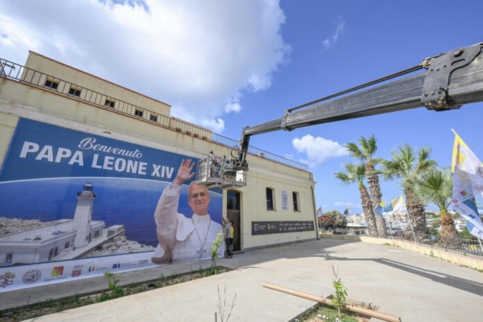 Trabajadores colocan una fotografía gigante antes de la visita del papa León XIV a Lampedusa, Italia, el 3 de julio de 2026. León XIV visitará el 4 de julio la isla italiana. EFE/EPA/CIRO FUSCO
