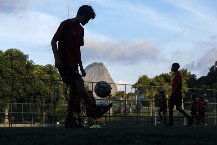 Fotografía de archivo del 11 de Junio de 2026 que muestra a personas de una escuela de fútbol entrenando en una cancha en la playa de Flamengo en Río de Janeiro (Brasil). EFE/ Antonio Lacerda
