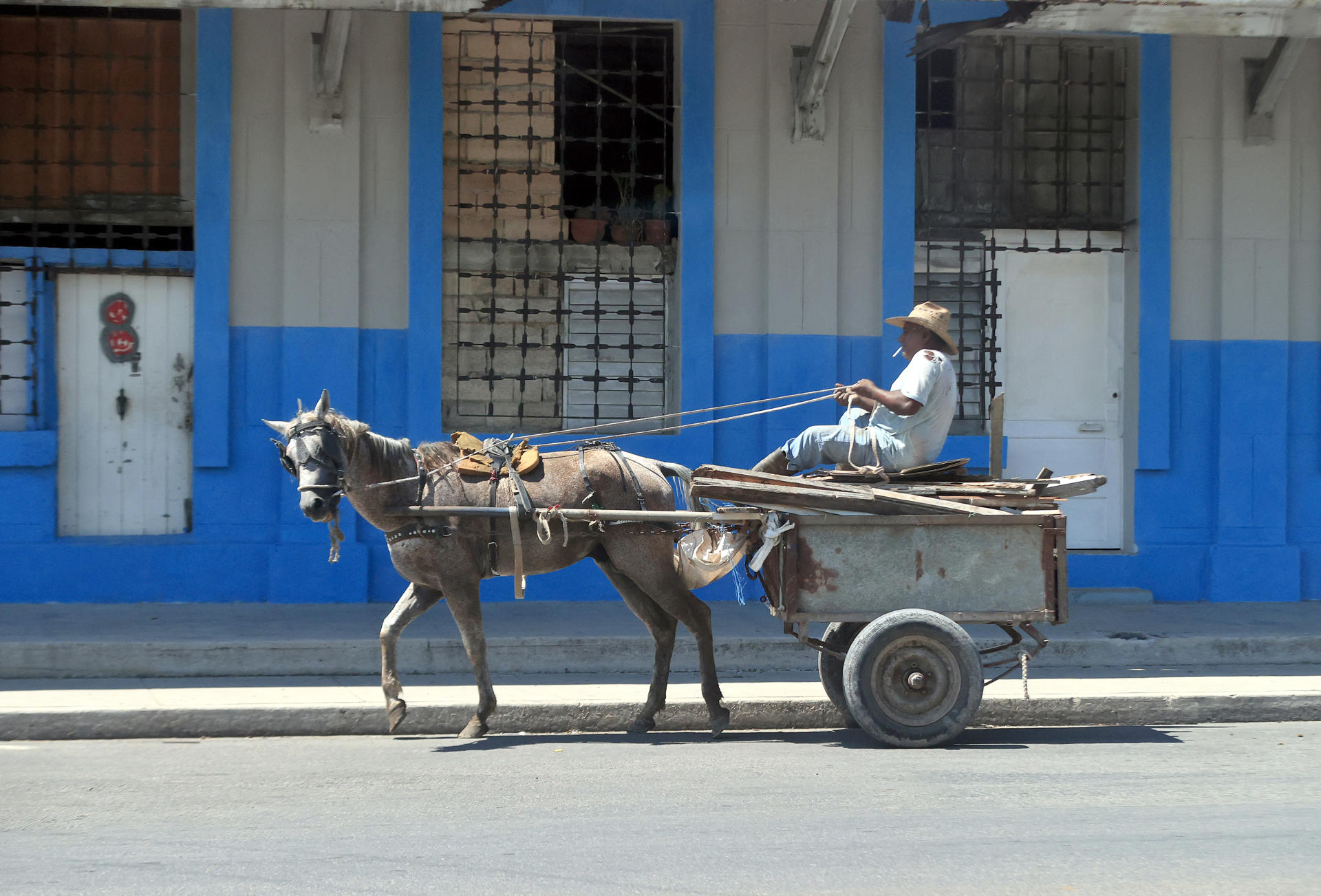 Una persona se transporta en un coche halado por un caballo este jueves en La Habana (Cuba). EFE/ Ernesto Mastrascusa
