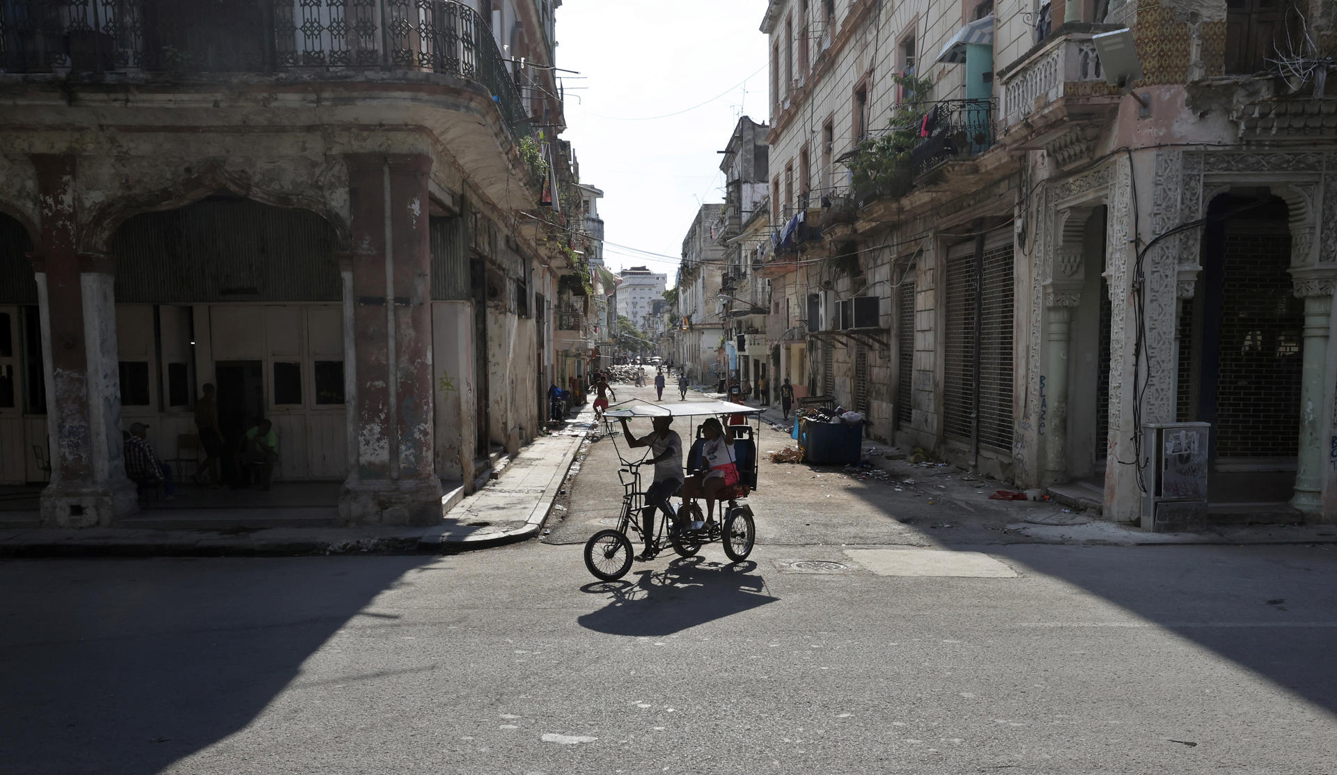 Personas se transportan en un bicitaxi este jueves en La Habana (Cuba). EFE/ Ernesto Mastrascusa
