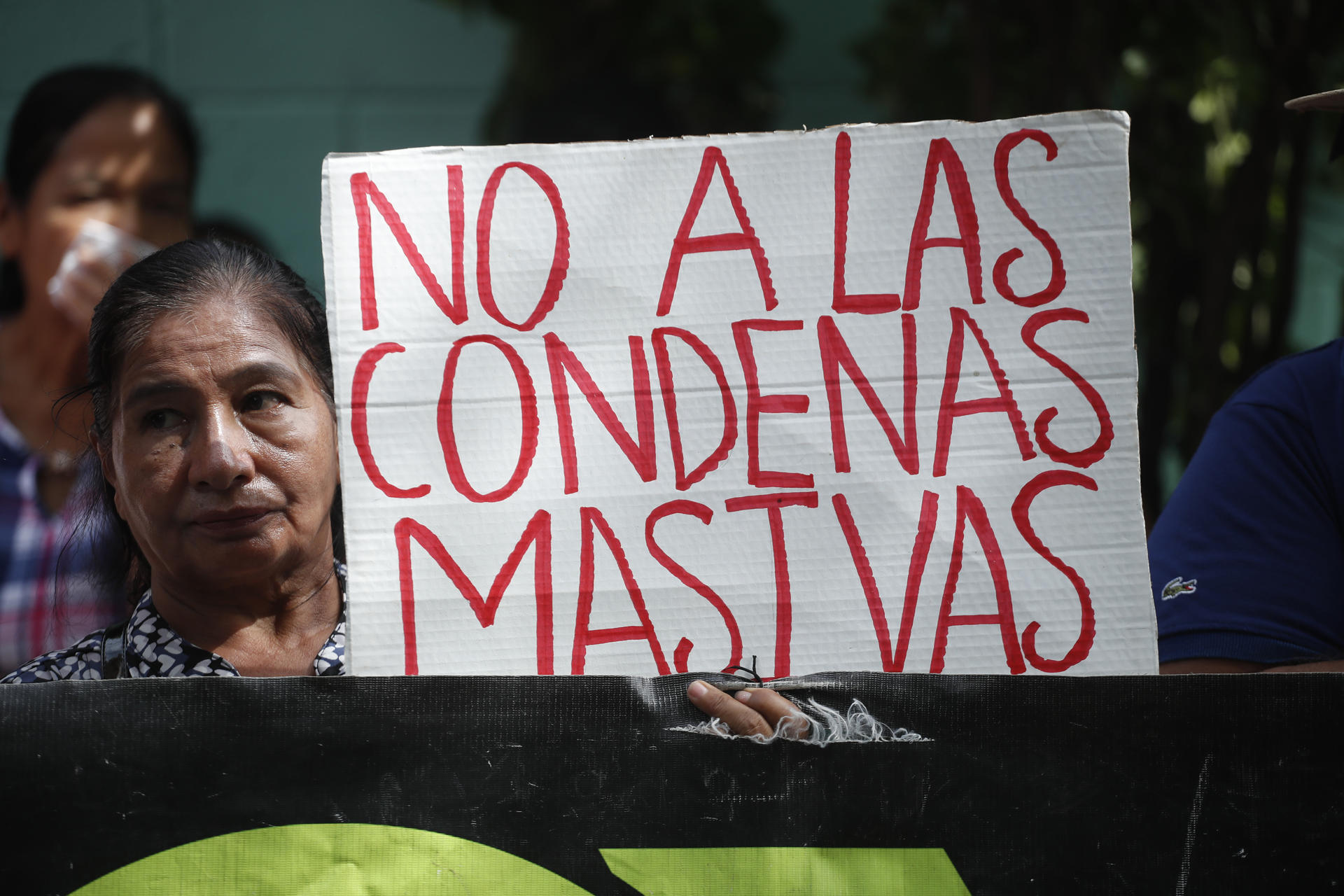 Una integrante de la organización Movimiento de Víctimas del Régimen de Excepción (Movir) protesta contra las audiencias masivas que lleva a cabo la Justicia, en el marco del polémico régimen de excepción, pidiendo que los procesos penales sean "justos" y "transparentes", en Soyapango, San Salvador (El Salvador). EFE/ Rodrigo Sura
