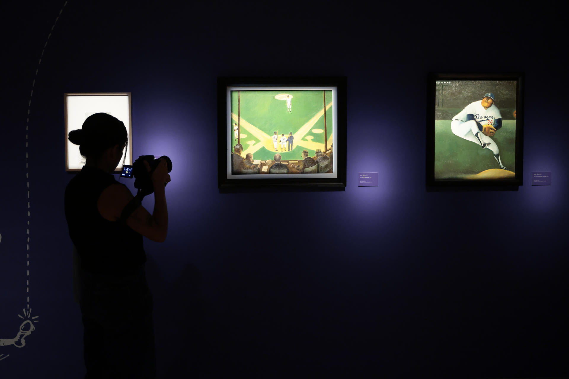 Un periodista recorre este viernes la exposición '¡México-México-México! Abel Quezada entre arte y deporte' que será inaugurada el próximo domingo en el Museo la luz, en Ciudad de México (México). EFE/José Méndez
