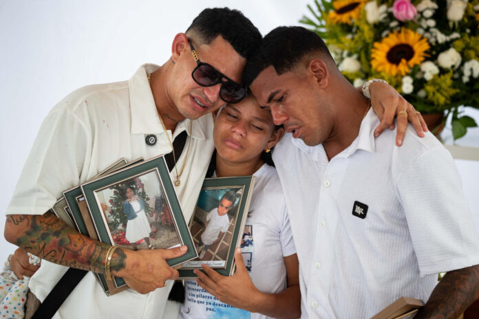 Leonardo Suárez (i) fue captado este 3 de julio al llorar durante el funeral de su mamá, su esposa, sus dos hijas y un sobrino, así como a la abuela de su mujer, víctimas de los terremotos del pasado 24 de junio, en Catia La Mar (La Guaira, Venezuela). EFE/Ronald Peña
