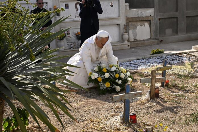 El papa León XIV deposita una ofrenda floral en una tumba durante una parada en el cementerio local, como parte de su visita pastoral a la isla de Lampedusa, en el sur de Italia, el 4 de julio de 2026. EFE/EPA/CIRO FUSCO / POOL
