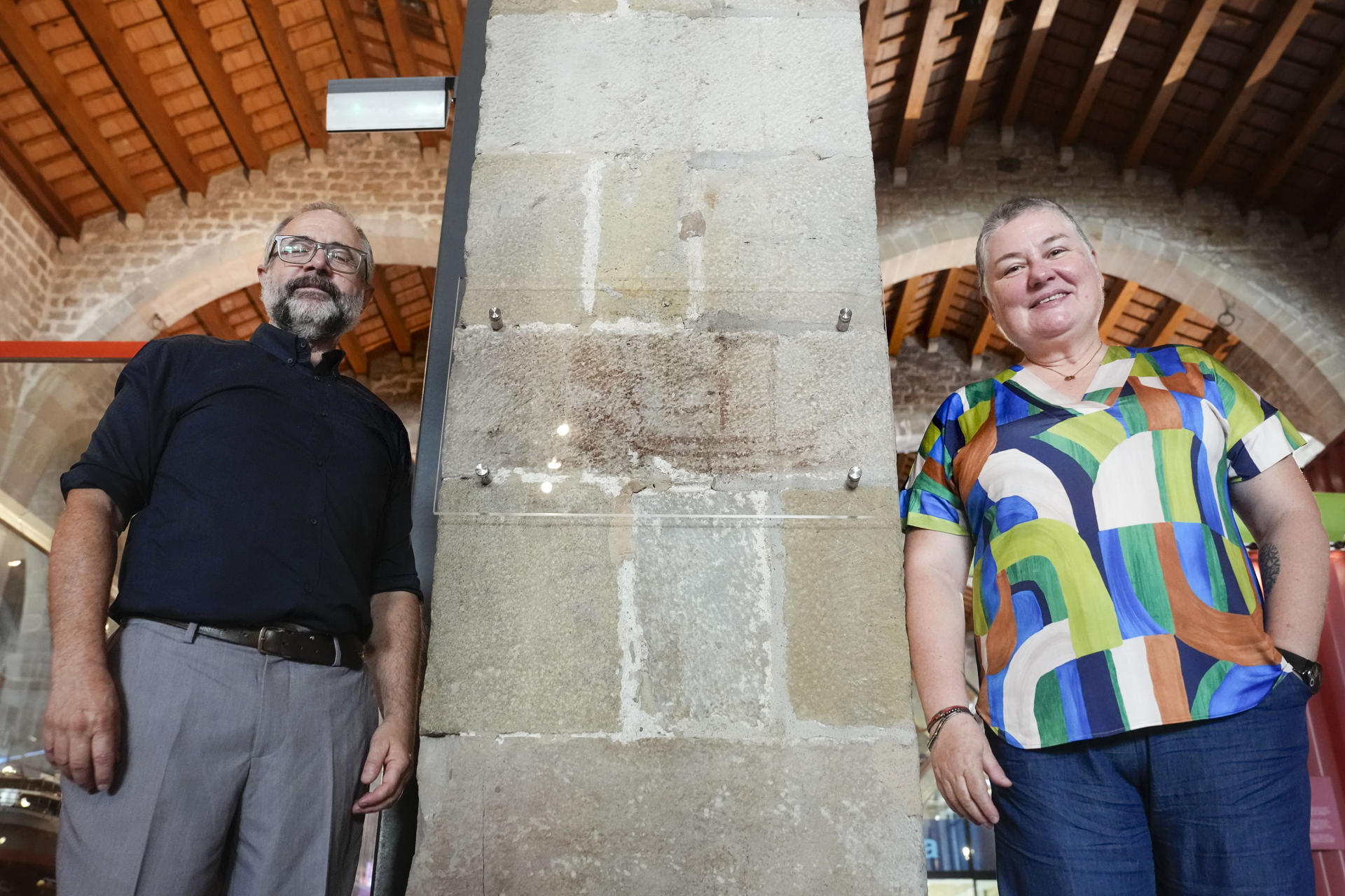 La historiadora y arqueóloga Gemma Garcia Hernando (i) posa junto al director del Museo Marítimo, Enric García (i) y recuerda en una entrevista con EFE, como descubrió el dibujo de un antiguo navío que estava a la vista de todo el mundo, incluidos numerosos estudiosos de la historia de la navegación, pero nadie había reparado en él. Y eso que estaba a la altura de los ojos, en una columna de una de las principales salas del Museu Marítim de Barcelona. EFE/Enric Fontcuberta.