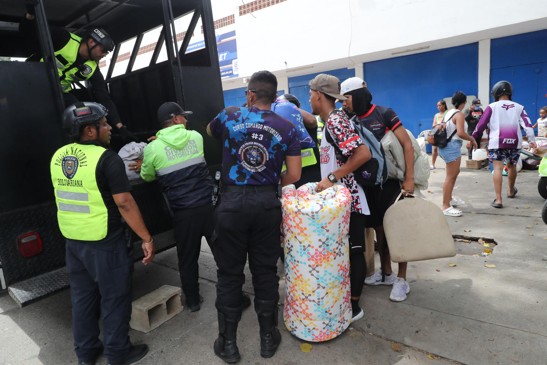 Personas hablan con policías este sábado cerca a edificios afectados por los terremotos ocurridos en la zona de Caraballeda, en La Guaira (Venezuela). EFE/ Raúl Martínez
