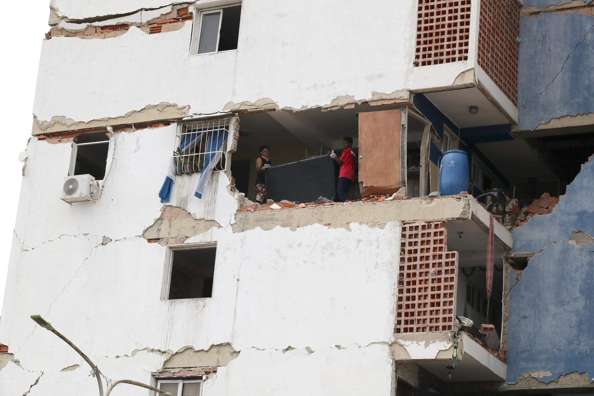 Personas sacan este sábado sus pertenencias de un edificio afectado por los terremotos ocurridos en la zona de Caraballeda, en La Guaira (Venezuela). EFE/ Raúl Martínez
