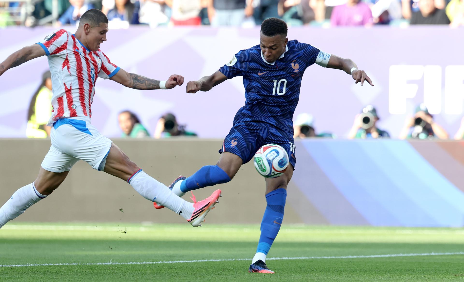 El paraguayo Juan José Cáceres intenta evitar el remate de Kylian Mbappé. EFE/EPA/SARAH YENESEL