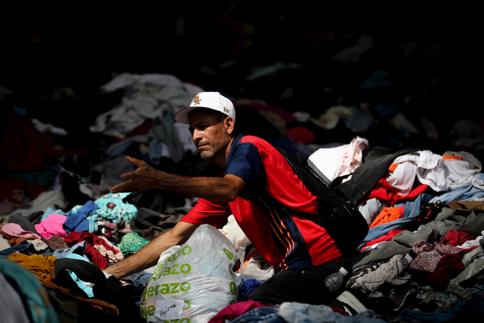Una persona selecciona ropa en La Guaira (Venezuela). EFE/ Raúl Martínez