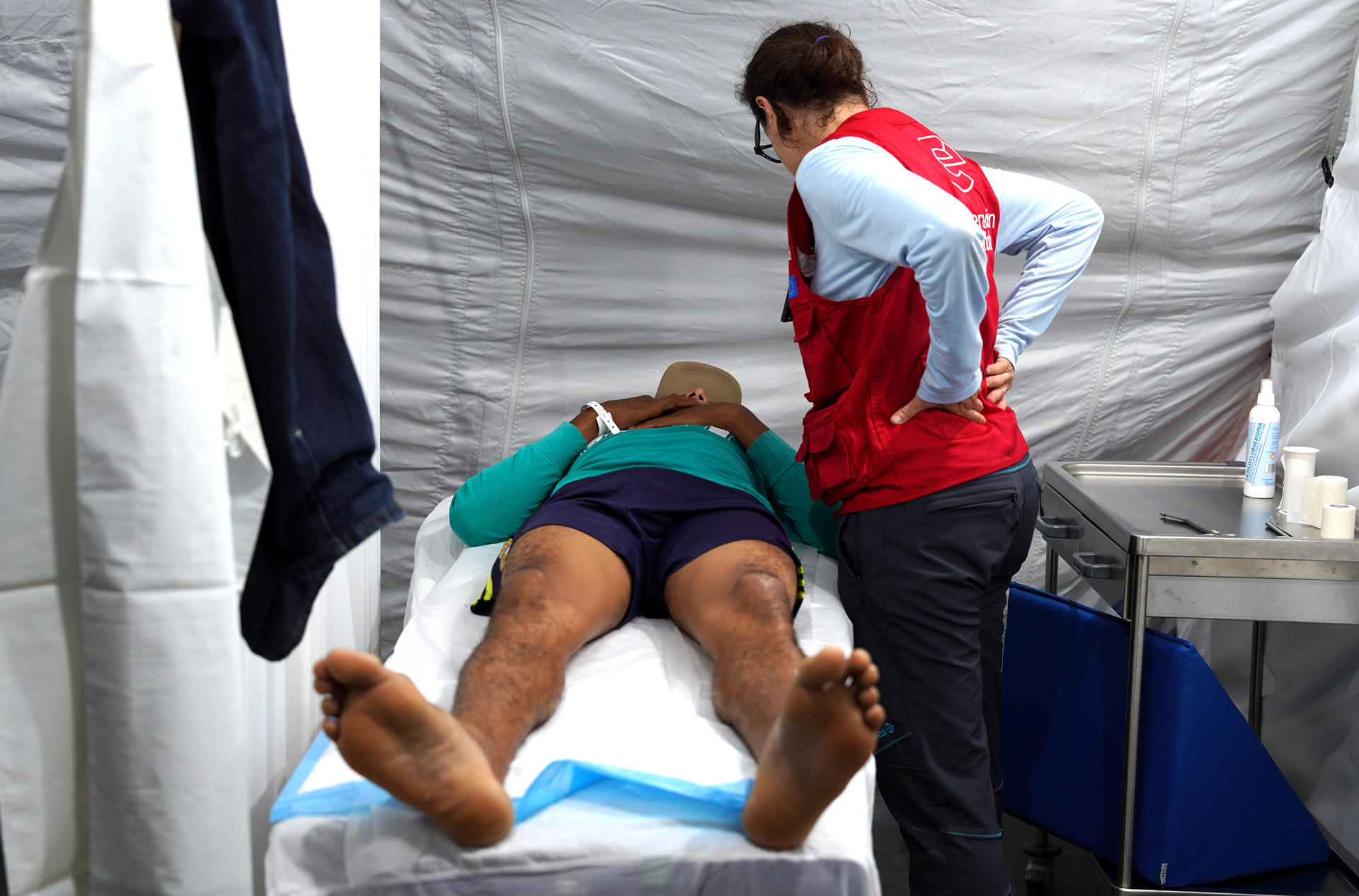 Fotografía cedida que muestra a una voluntaria del grupo START (Equipo Técnico de Ayuda y Respuesta de Emergencia) coordinado por AECID (d) brindando atención a una persona durante la inauguración de un hospital este sábado, en Caracas (Venezuela). EFE/ AECID
