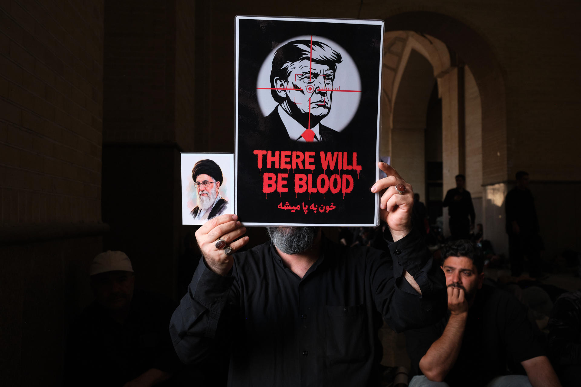 Un hombre muestra un cartel del presidente estadounidense, Donald Trump, en el que aparece en el radar de una ametralladora con el mensaje: "Se derramará sangre" en ingles y persa, durante los rezos funerarios del asesinado líder supremo de Irán Alí Jameneí en la mezquita Mosala de Teherán este domingo. Irán celebró el rezo fúnebre por el asesinado líder supremo Alí Jameneí que contó con la participación de decenas de miles de personas, entre ellas altos cargos del país, en el segundo día de los funerales públicos en el que resonaron las llamadas de venganza contra Estados Unidos e Israel. EFE/Jaime León
