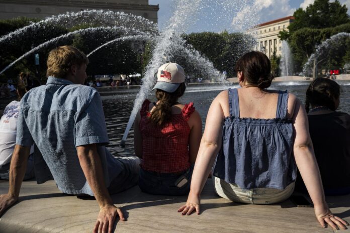 Personas se refrescan en la fuente del Jardín de Esculturas de la Galería Nacional de Arte, en el National Mall de Washington, DC (EE.UU.), durante temperaturas de calor extremo. EFE/GRAEME SLOAN

