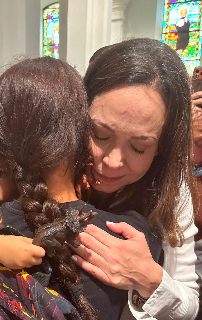Fotografía cedida por Comando Con Venezuela de la líder opositora de Venezuela y premio nobel de la paz María Corina Machado abrazando a una joven durante la celebración de una eucaristía este domingo en Ciudad de Panamá (Panamá). EFE/ Comando Con Venezuela
