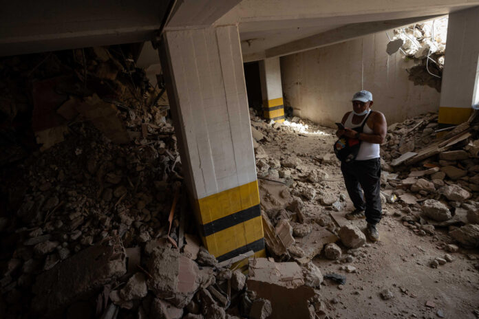 Una persona busca en medio de los escombros de un edificio este domingo, en La Guaira (Venezuela). EFE/ Ronald Peña R
