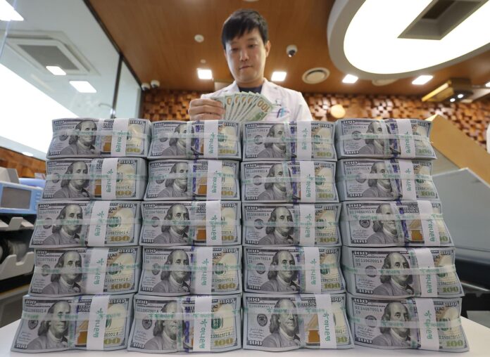 Fotografía de archivo de un empleado clasificando billetes de 100 dólares en el banco Hana en Seúl. EFE/ Yonhap PROHIBIDO SU USO EN COREA DEL SUR
