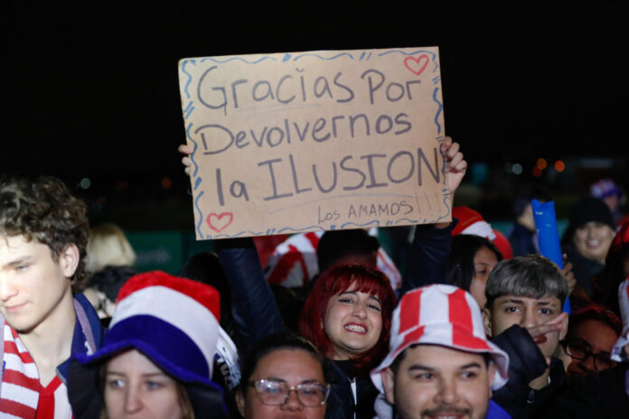 Seguidores de la selección paraguaya de fútbol esperan la llegada del equipo en el Aeropuerto Internacional Silvio Pettirossi, tras ser eliminada por Francia en los octavos de final de la Copa del Mundo, 6 de julio de 2026. EFE/ Juan Pablo Pino

