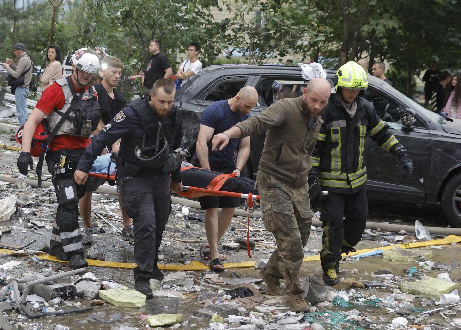 Rescatistas ucranianos transportan a un herido en el lugar de un ataque con misiles rusos en una zona residencial de Kiev, Ucrania, el 6 de julio de 2026, en medio de la invasión rusa. Según el Servicio Estatal de Emergencias, al menos 10 personas murieron y más de 43 resultaron heridas tras el ataque nocturno contra Kiev. La Fuerza Aérea reportó que Rusia lanzó 351 drones y 68 misiles de distintos tipos durante el ataque contra Ucrania, siendo Kiev el objetivo principal. (Rusia, Ucrania, Kiev) EFE/EPA/SERGEY DOLZHENKO
