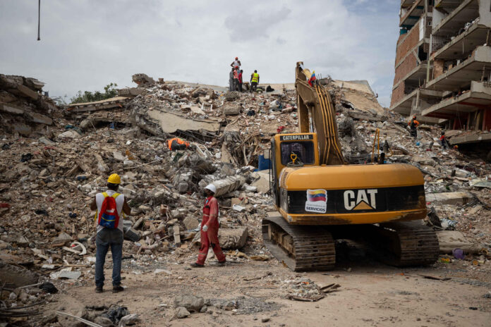 Integrantes de cuerpos de rescate trabajan junto a maquinaria pesada para remover escombros este domingo, en La Guaira (Venezuela). EFE/ Ronald Peña R
